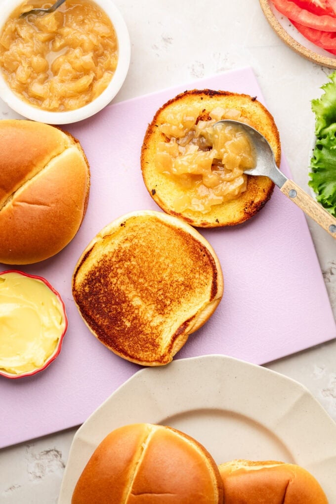 caramelized onion jam with spoon spread over toasted brioche bun