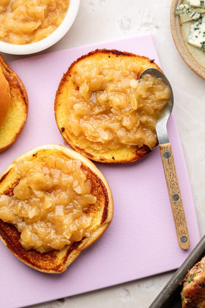 caramelized onion jam with spoon spread over toasted brioche bun