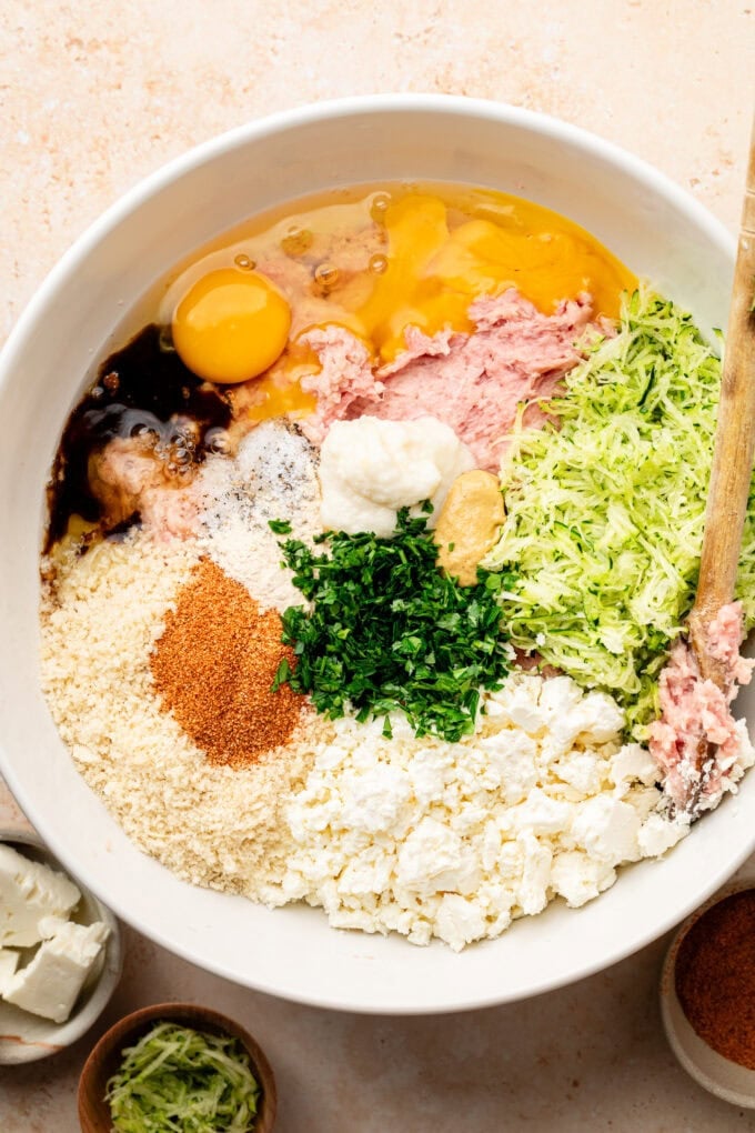 ground chicken with spices and eggs in large bowl