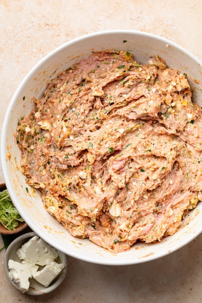 raw ground chicken mixed with spices in large bowl