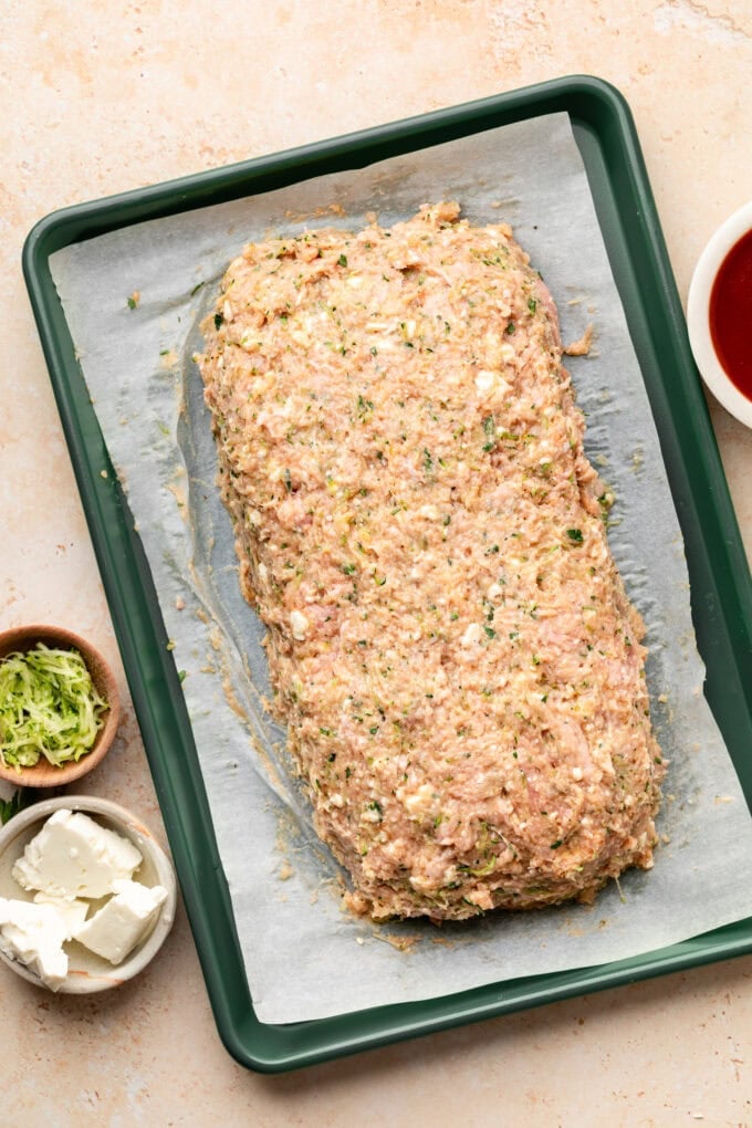 raw ground meat shaped on baking sheet