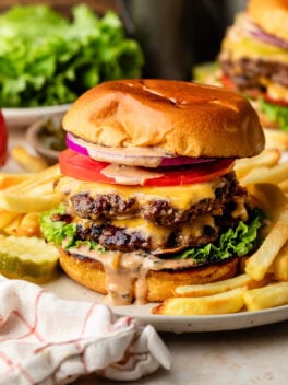 smash burger with burger sauce on white plate