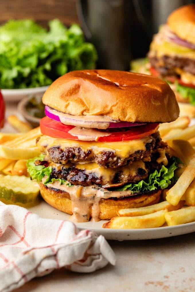 smash burger with burger sauce on white plate