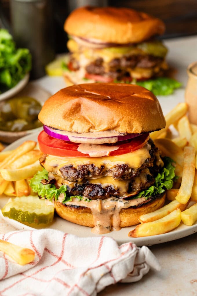 smash burgers on plates with fries