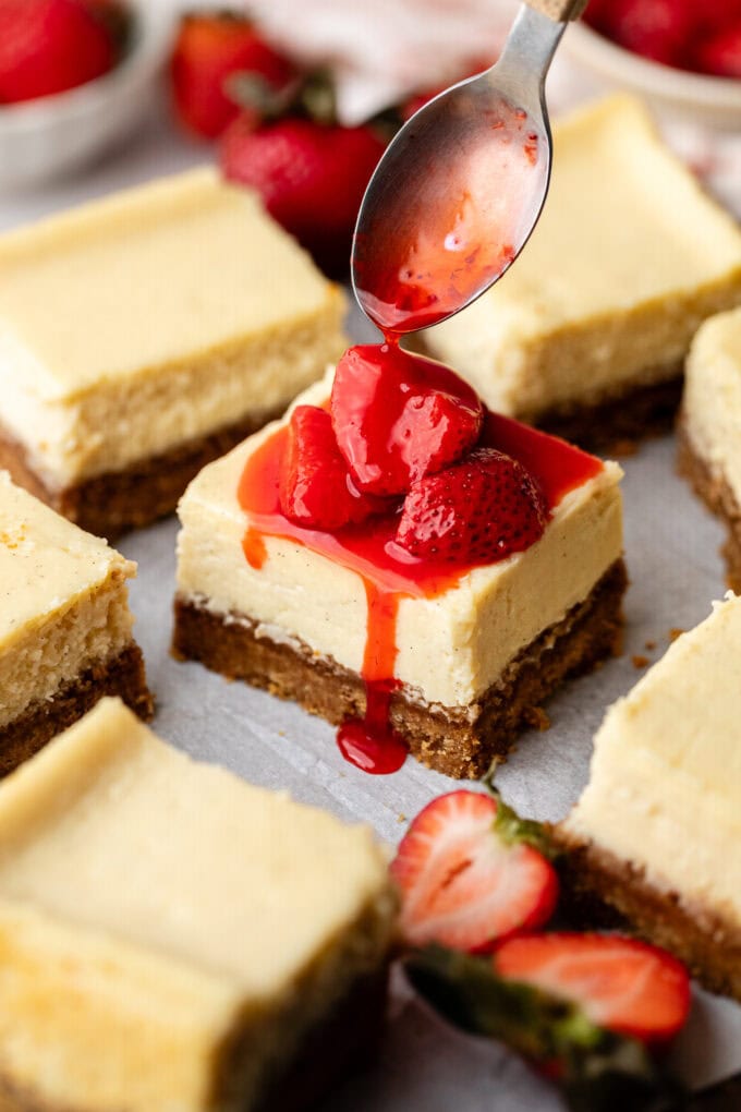strawberry compote spooned over vanilla cheesecake bars