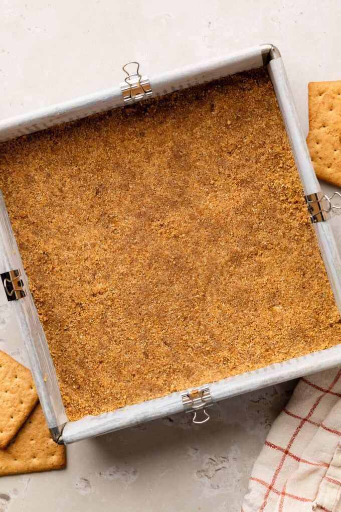 pressed graham cracker mixture in baking pan