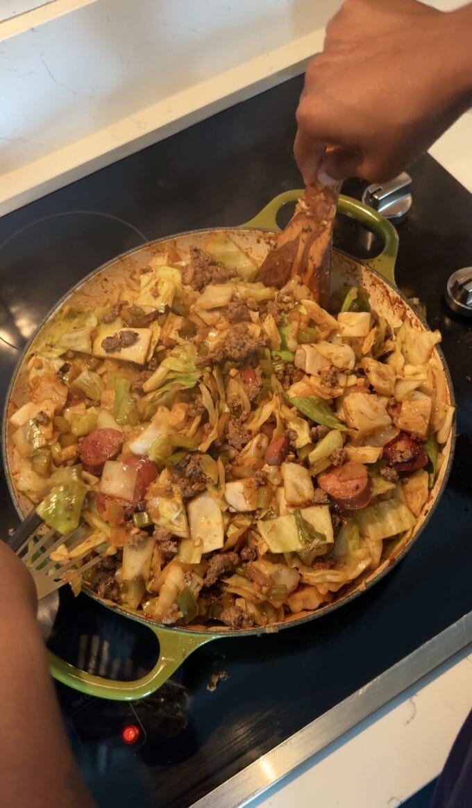 black hands tossing dirty cabbage in skillet
