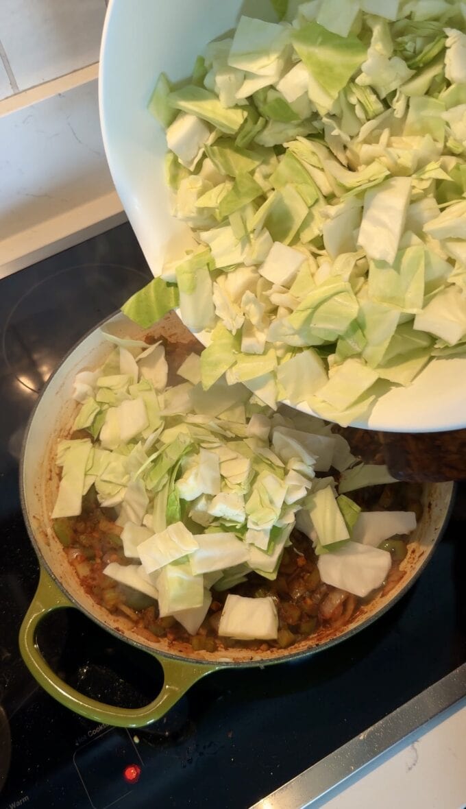 chopped green cabbage going into pot