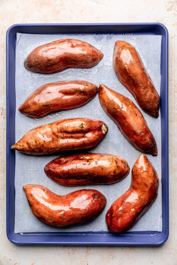 halved sweet potatoes with oil on baking sheet
