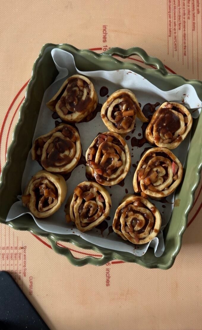 cut cinnamon rolls in green baking pan