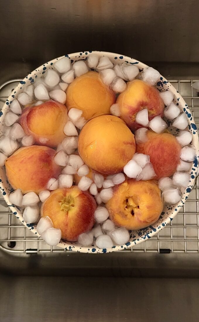 fresh peaches in bowl of ice water