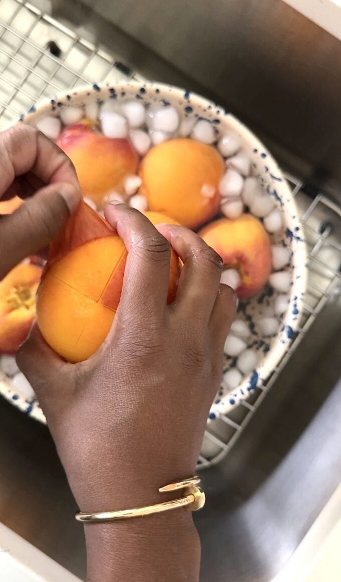 black hand peeling skin off of peach