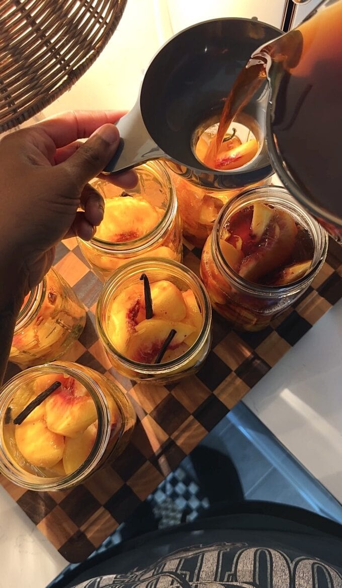 sweet tea being poured in jars with peaches